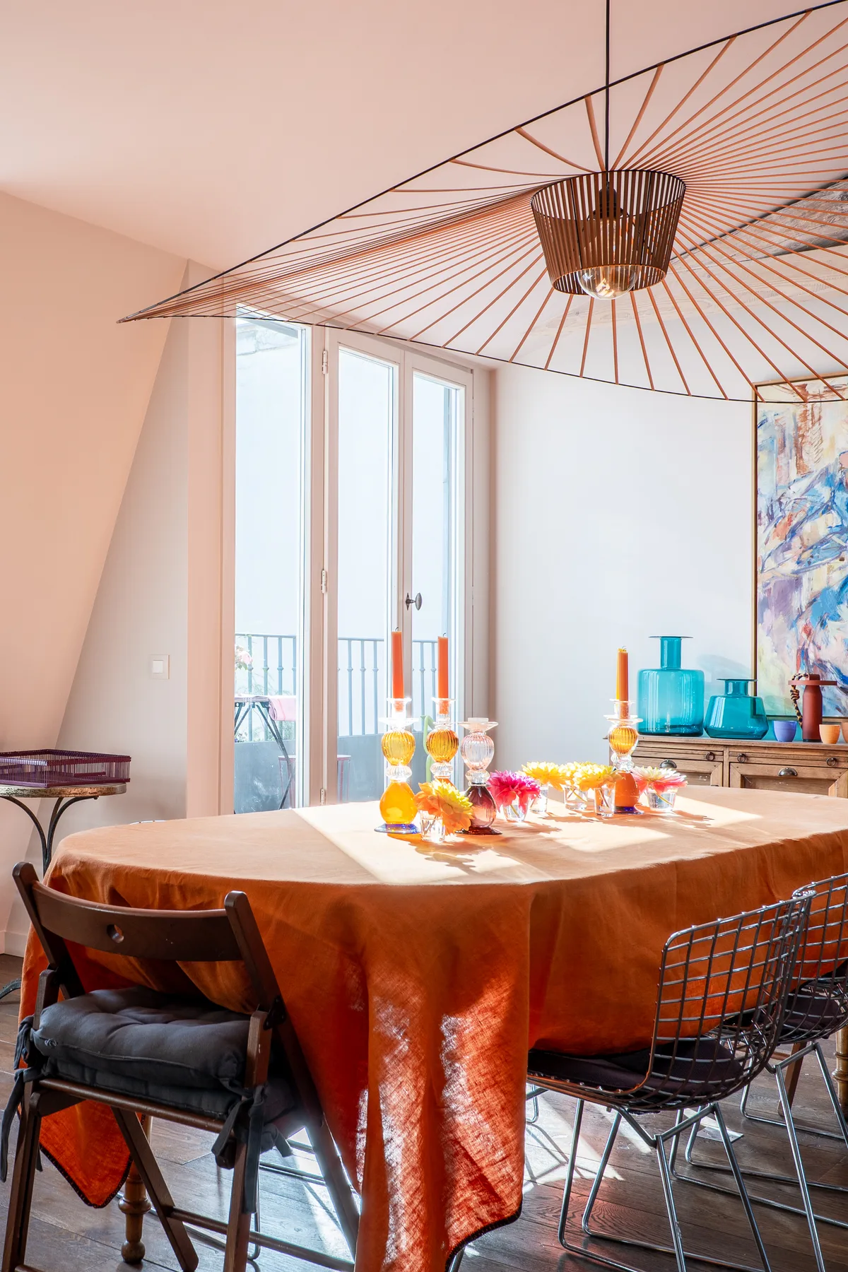 A dining area with a round table set beneath a decorative ceiling light.