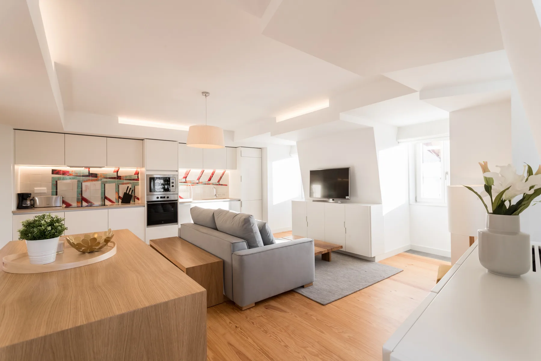 Luminoso salón-comedor con asientos, un televisor y una mesa de comedor.