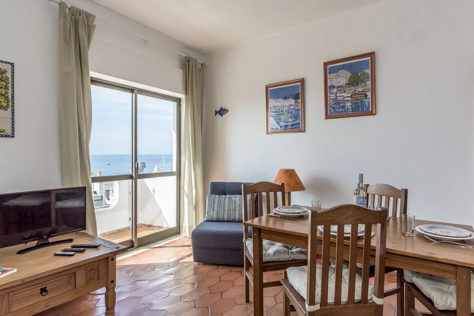 Una zona de comedor y estar se abre a un balcón con vistas al mar.
