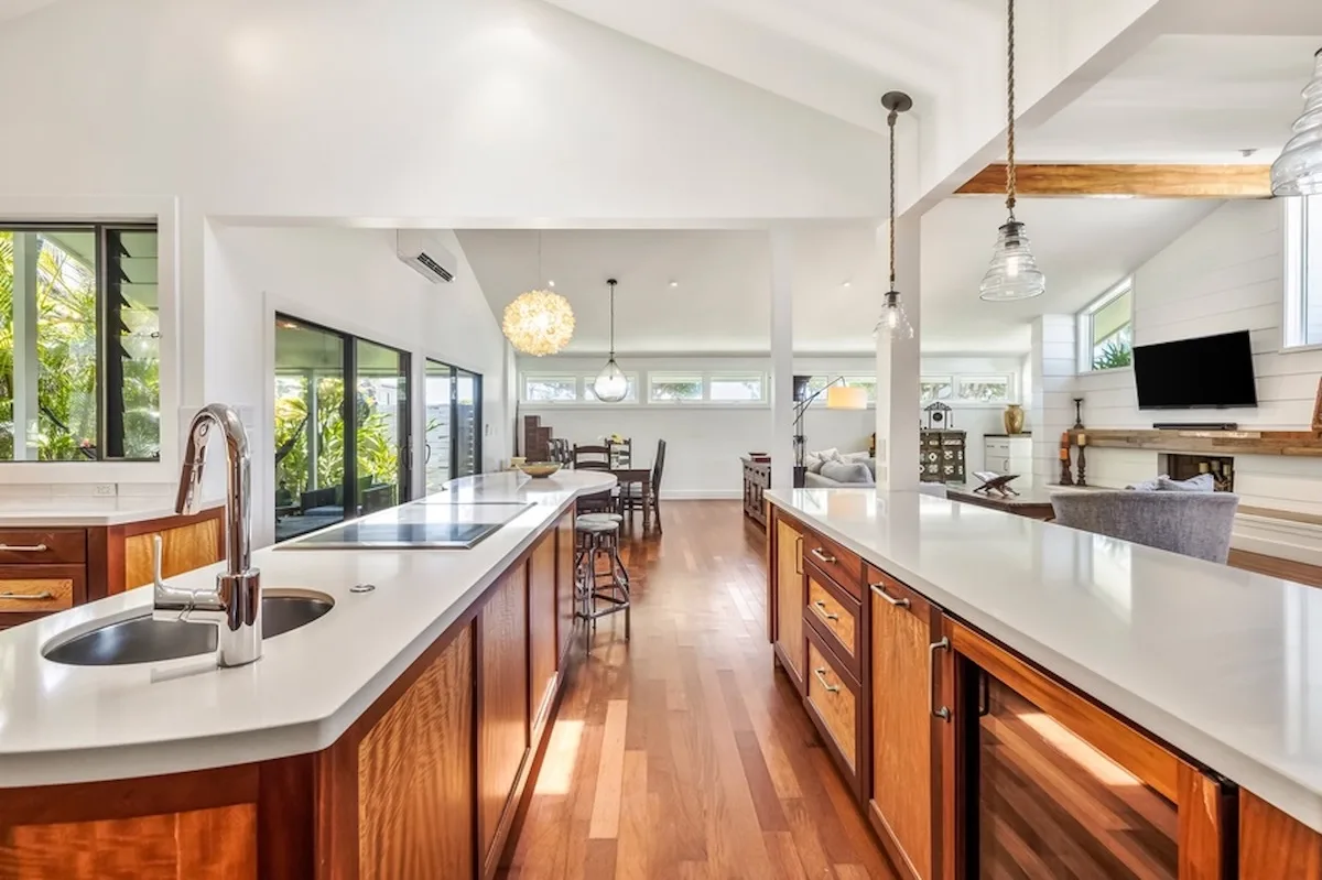 Una cocina y comedor diáfanos y luminosos, con largas encimeras y armarios de madera.