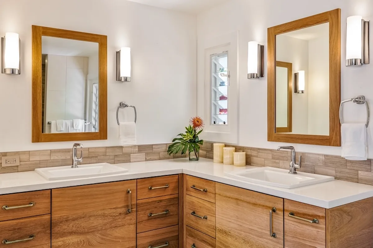 Un tocador de baño con dos lavabos, espejos y gabinetes de madera.