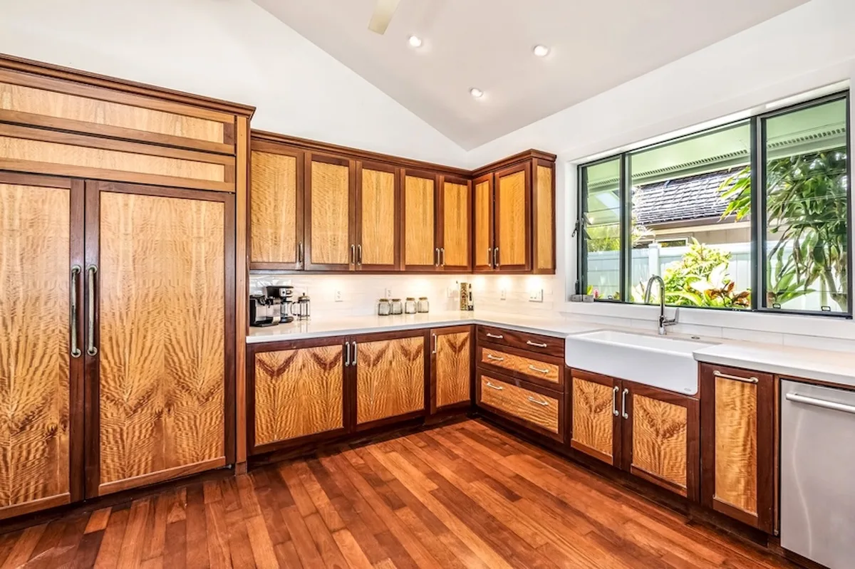 Una cocina luminosa con gabinetes de madera, una encimera larga y una ventana amplia.