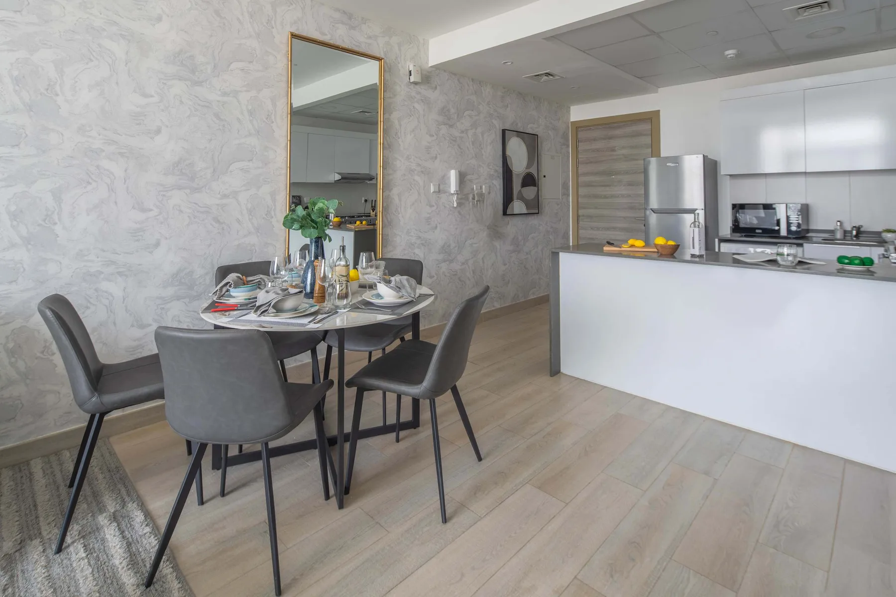 Comedor y cocina de concepto abierto, con una mesa puesta y una barra.