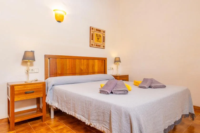 Un dormitorio con una cama grande, cabecero de madera y mesitas de noche a juego.