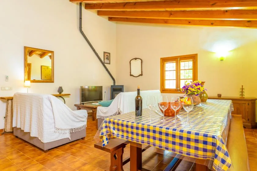 Un comedor con un mantel a cuadros y un arreglo floral.