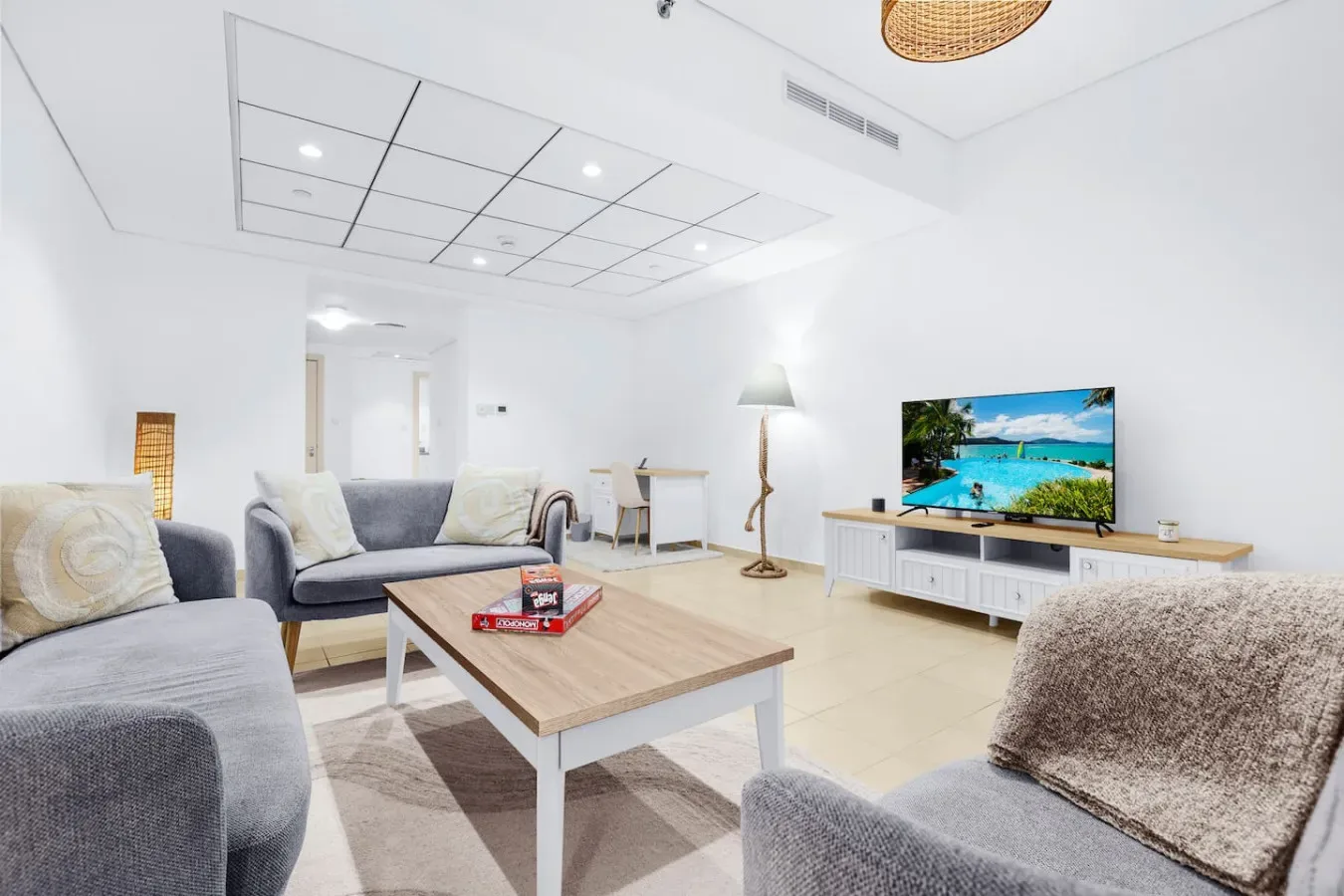 Una sala luminosa con asientos, una mesa de centro y un televisor.