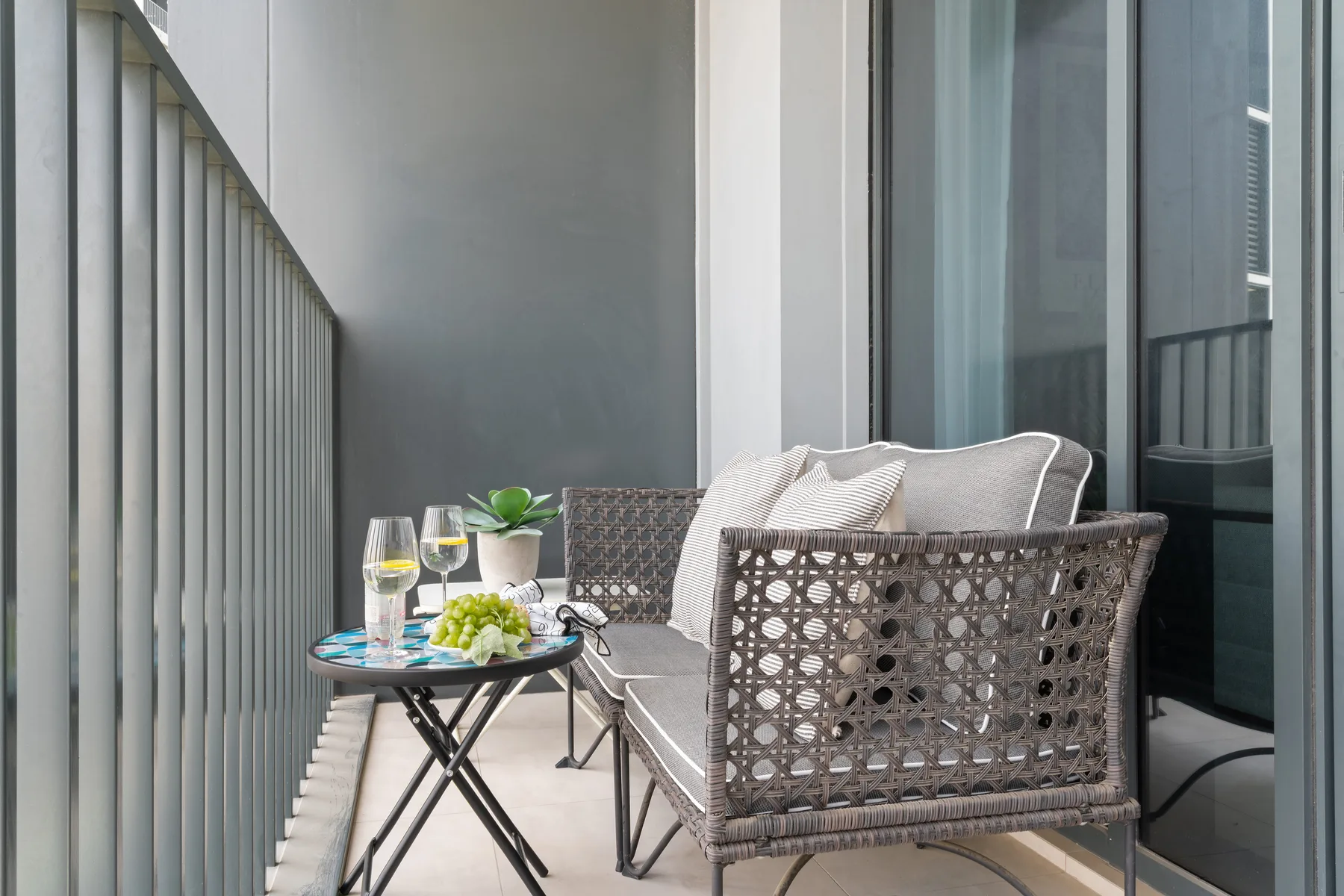A balcony seating area with cushioned chairs and a small table.