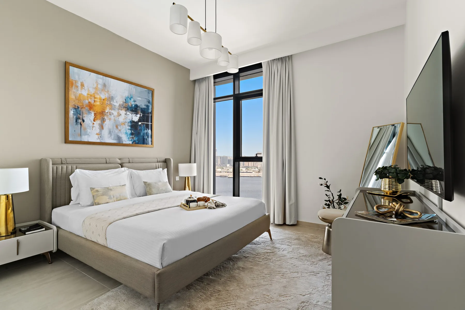 A bright bedroom with a neatly made bed and a large window.