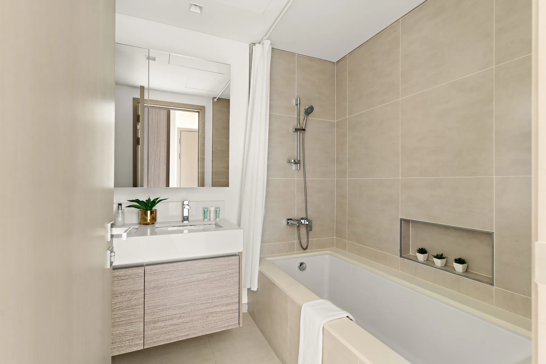 A bathroom with a bathtub, shower, and sink vanity.