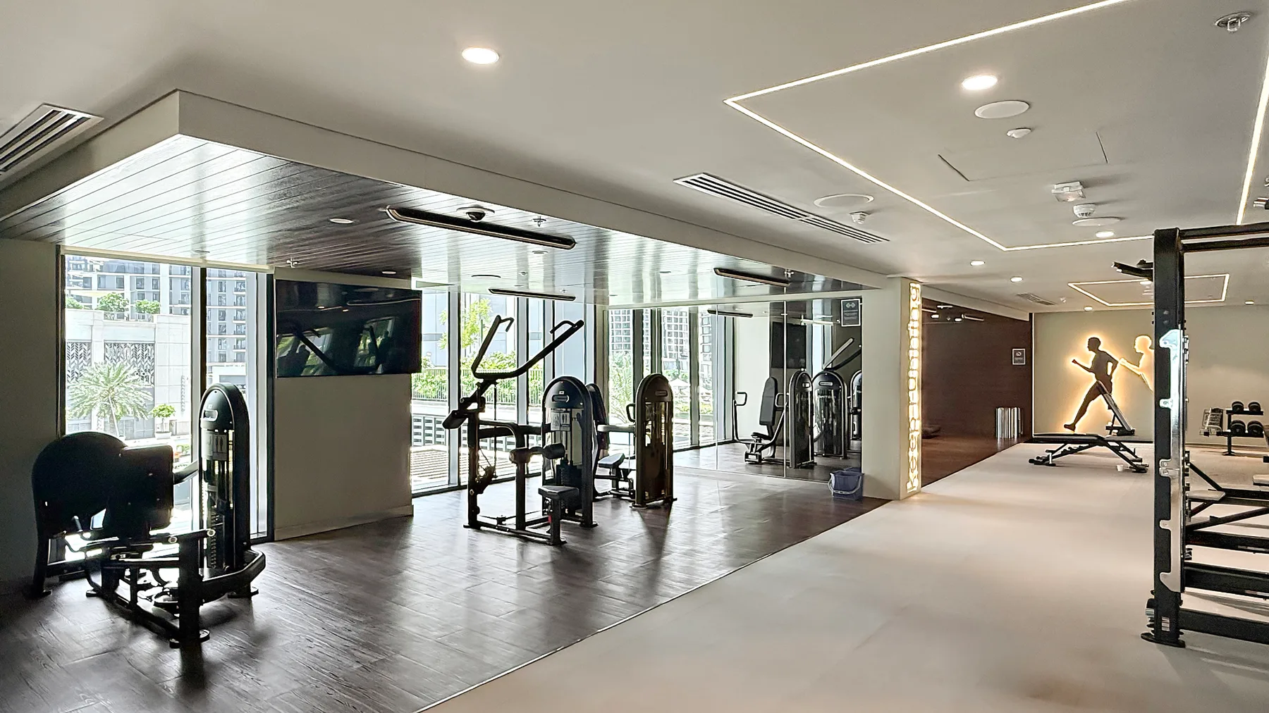 A gym with exercise machines and large windows.