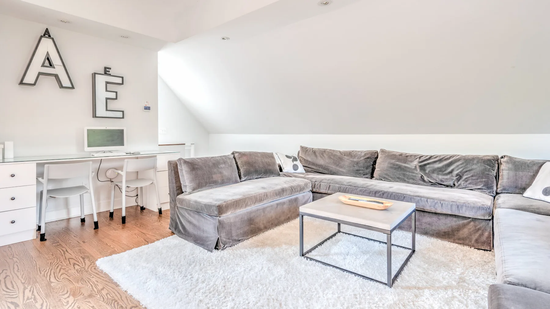 Una sala de estar luminosa con sofá seccional y mesa de centro.
