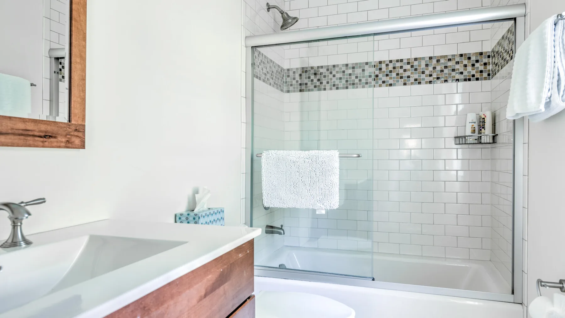 Un baño con una ducha alicatada y un lavabo.