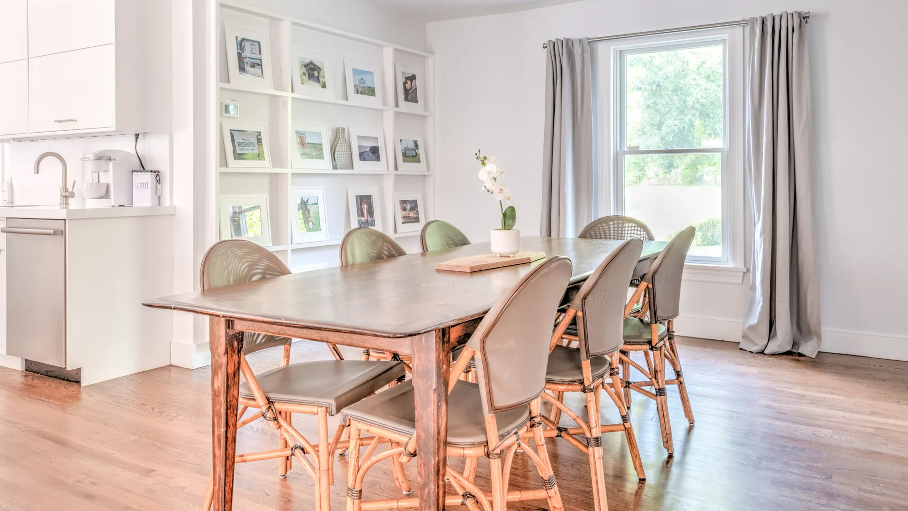Un comedor luminoso con una mesa larga, asientos y una ventana.