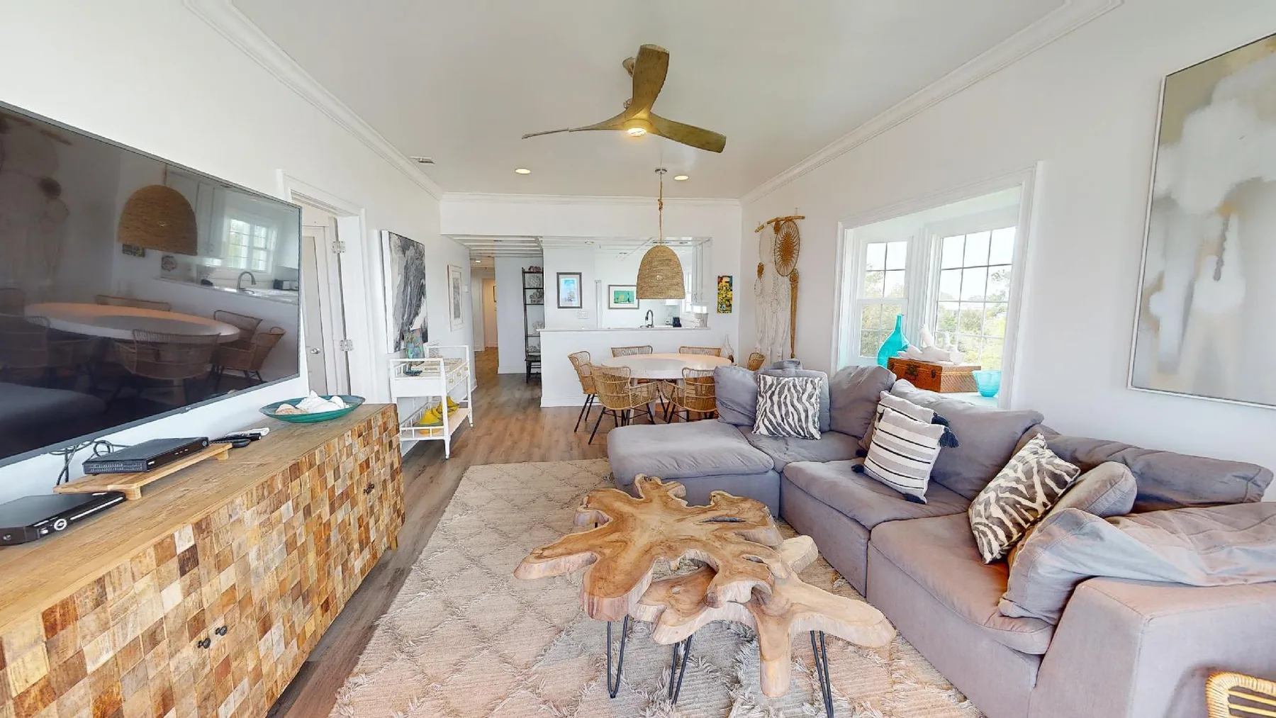 A bright living room with a sectional seating area and dining space.
