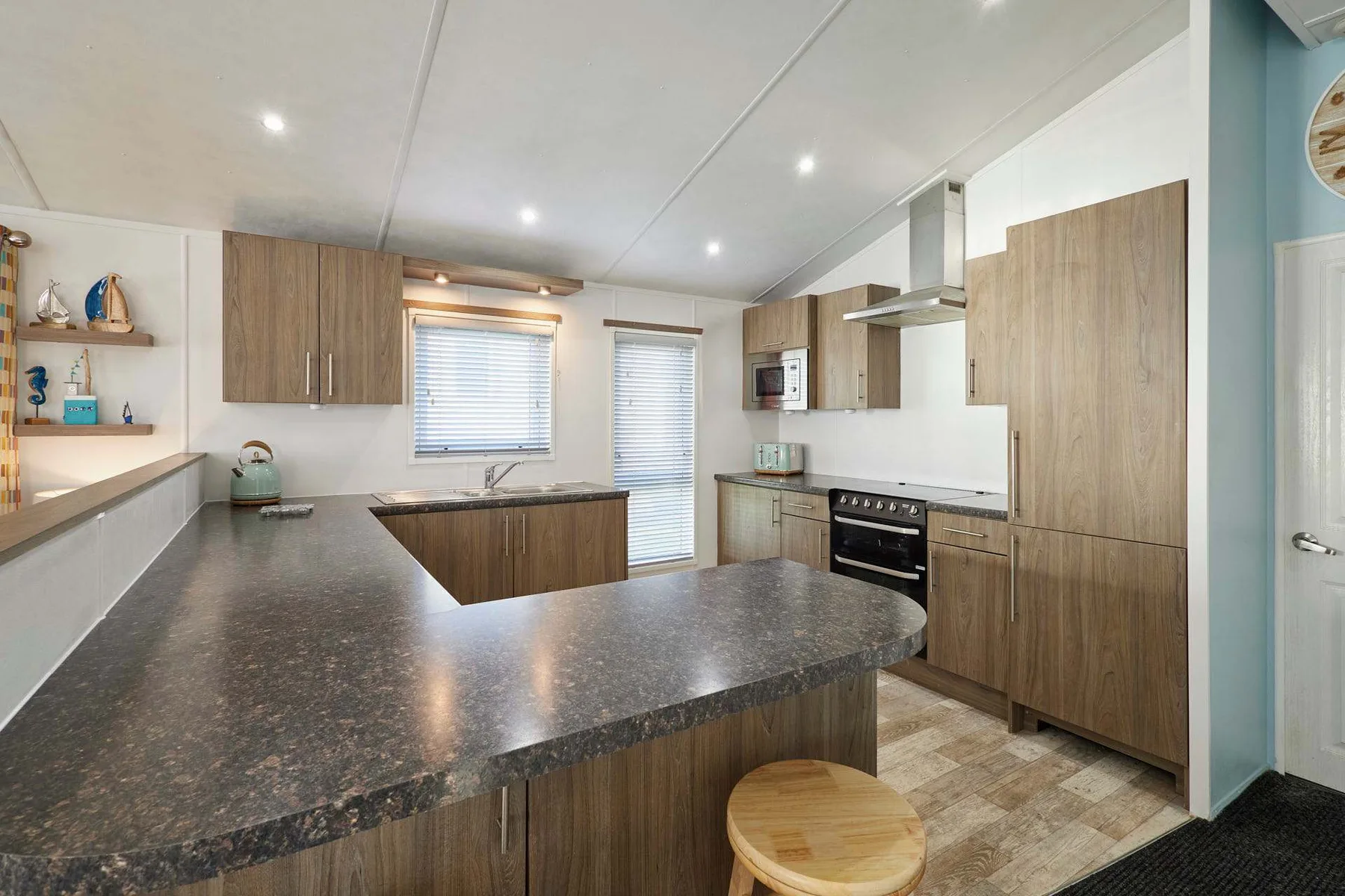 Una cocina moderna con gabinetes de madera, electrodomésticos de acero inoxidable y una amplia encimera.