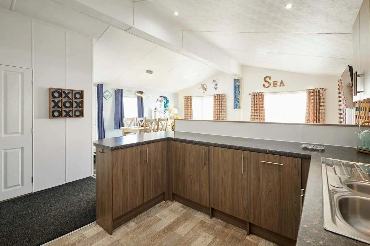 Una cocina con una isla de frentes de madera y un fregadero junto a la encimera.