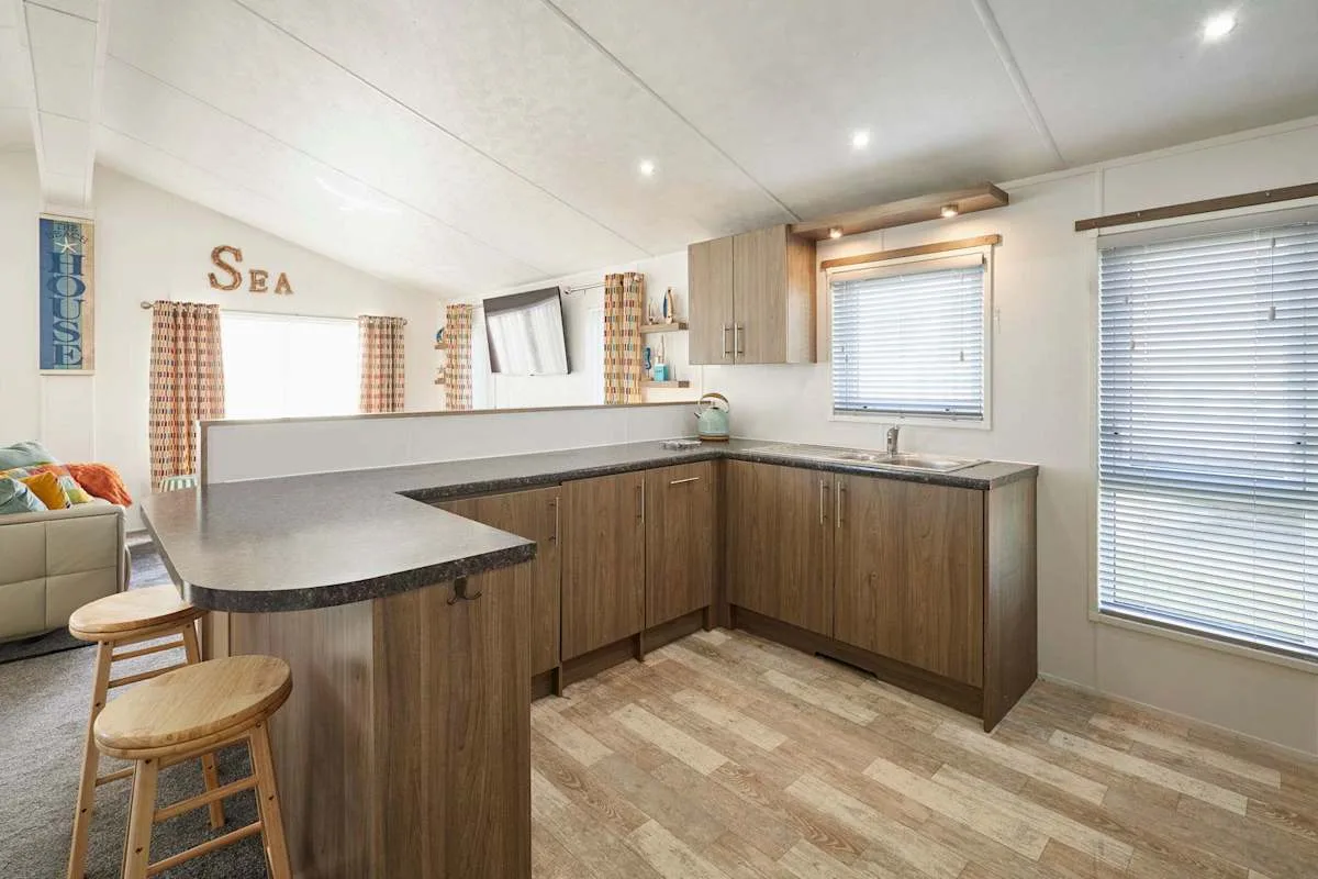 Una cocina con gabinetes en tonos de madera y una barra curva.