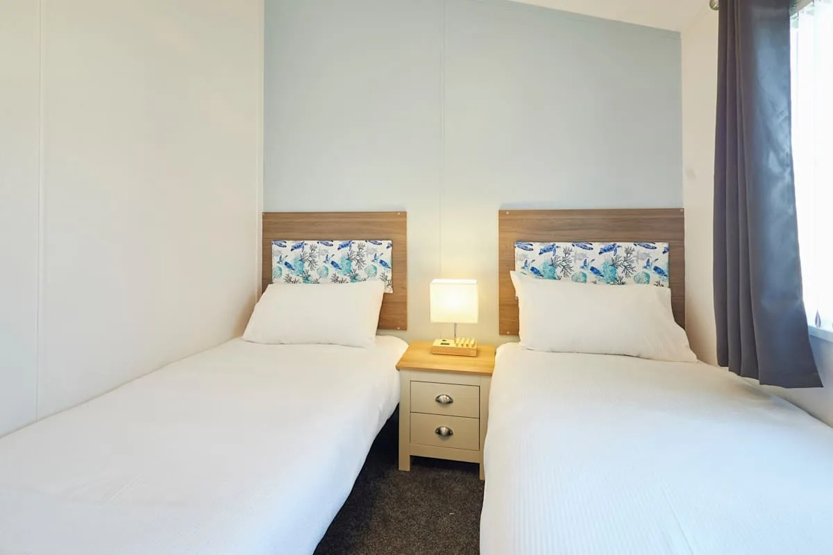 Un dormitorio con dos camas individuales y una mesita entre ellas.