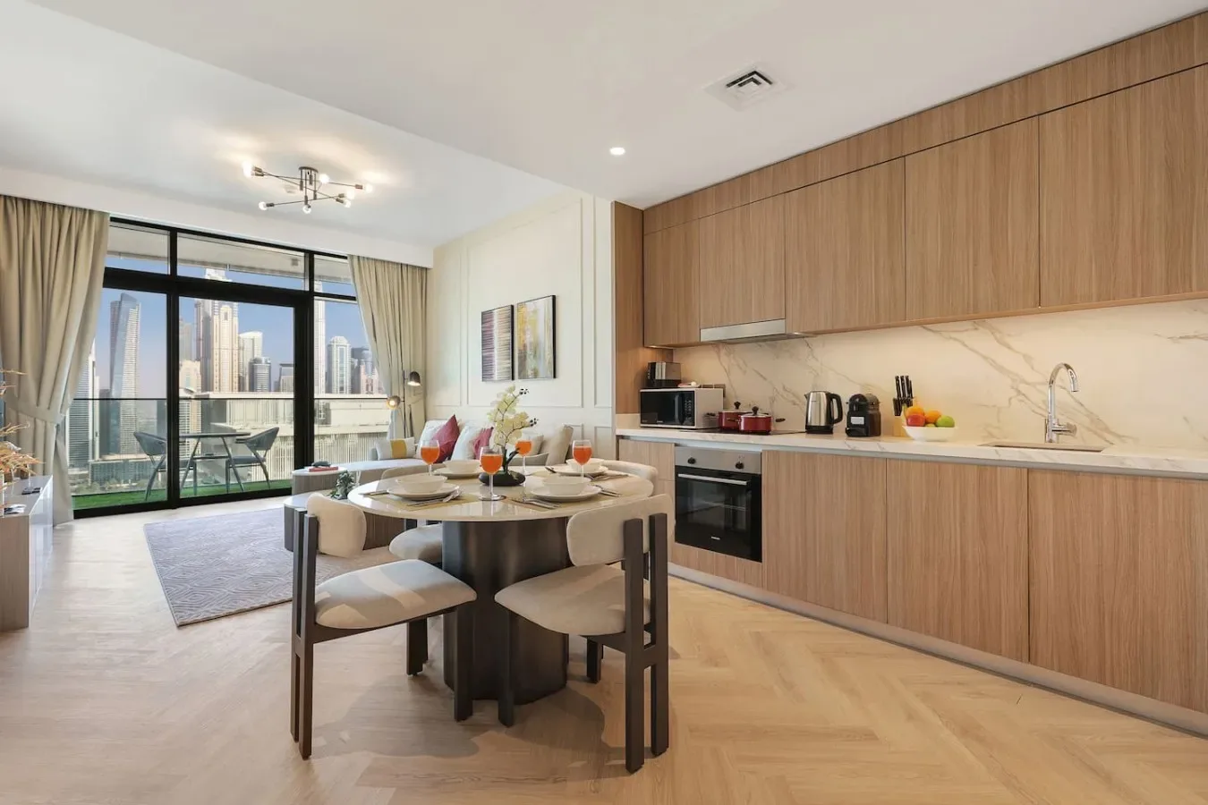 Una zona abierta de comedor y cocina, con una mesa junto a grandes ventanales.
