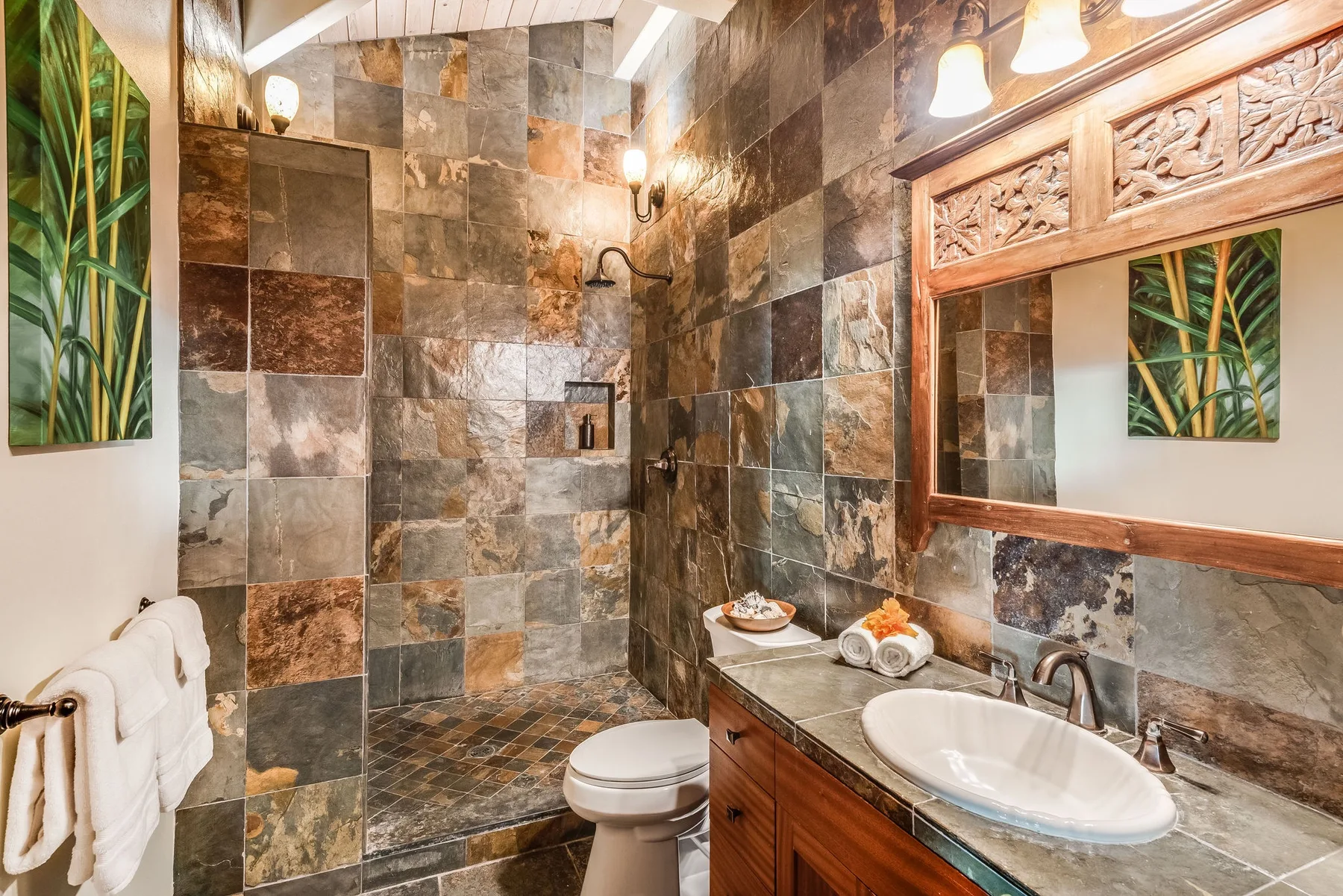 Un baño con ducha de azulejos, lavabo y espejo de pared.