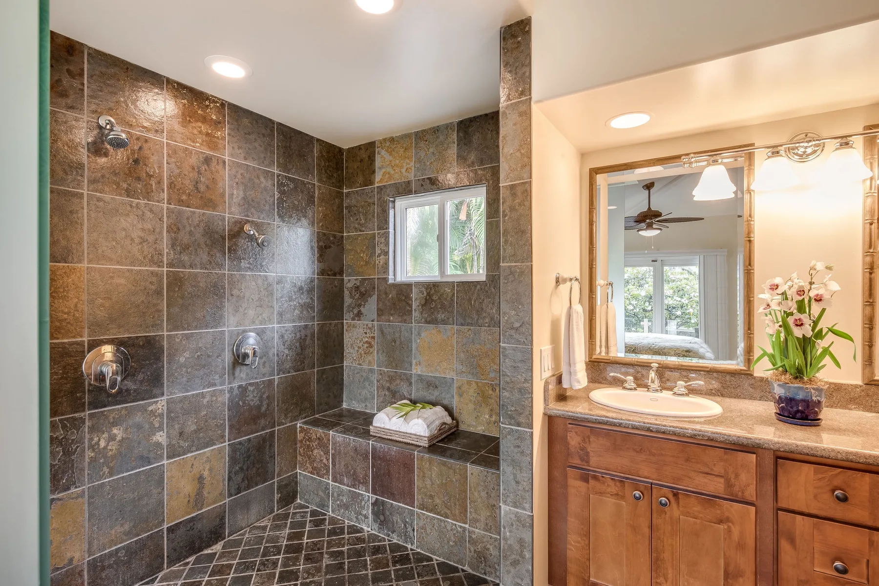 Un baño con ducha de azulejos y tocador de madera.