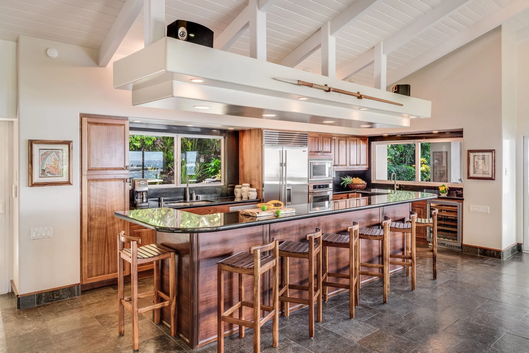Una cocina amplia con una isla larga y asientos de madera.