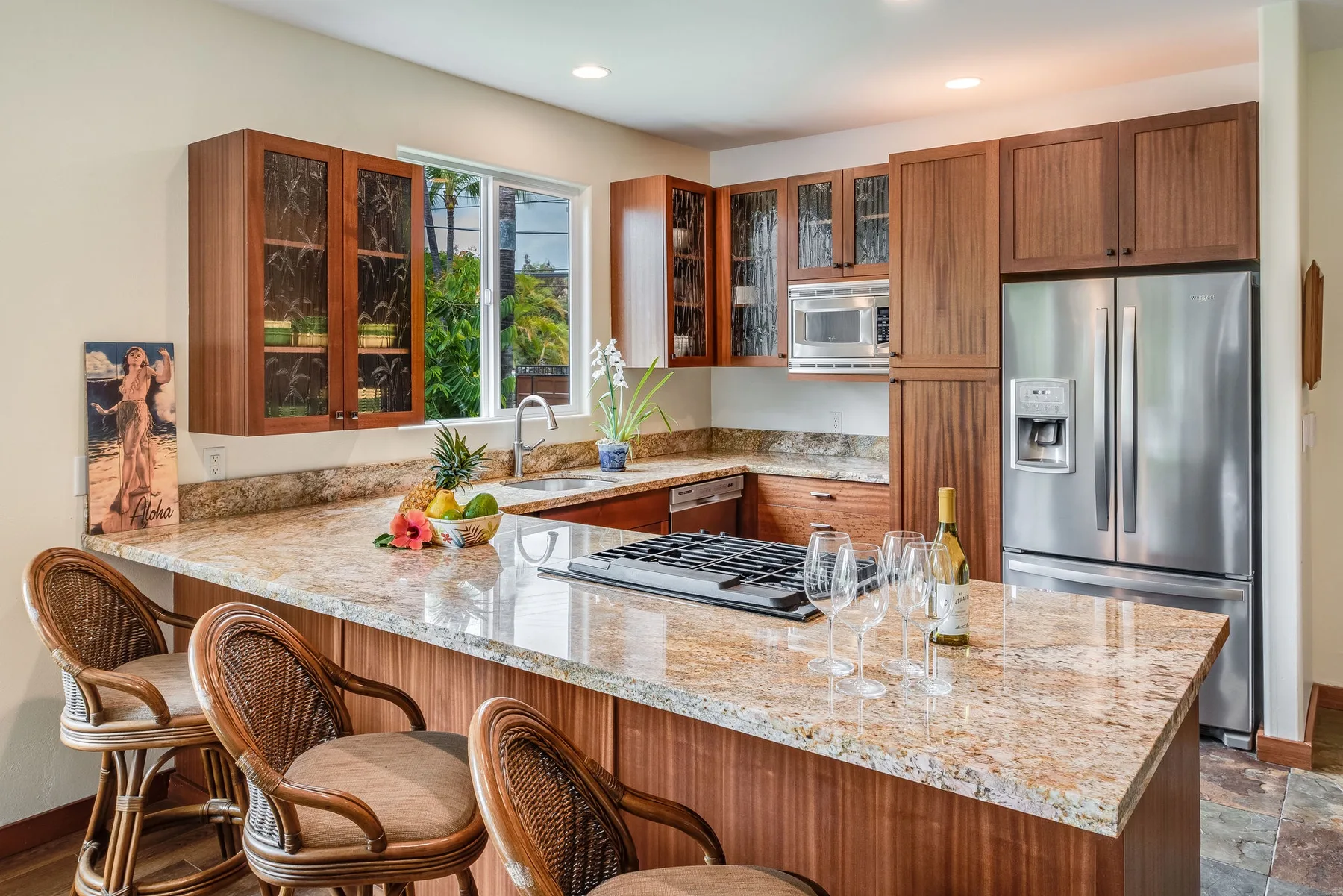 Una cocina amplia con gabinetes de madera, una isla grande y electrodomésticos de acero inoxidable.