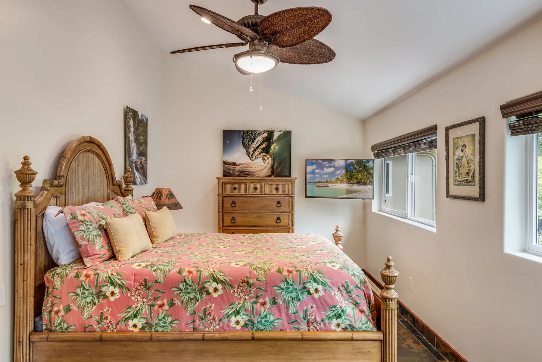 Un dormitorio con una cama de madera cubierta con una colcha floral colorida.