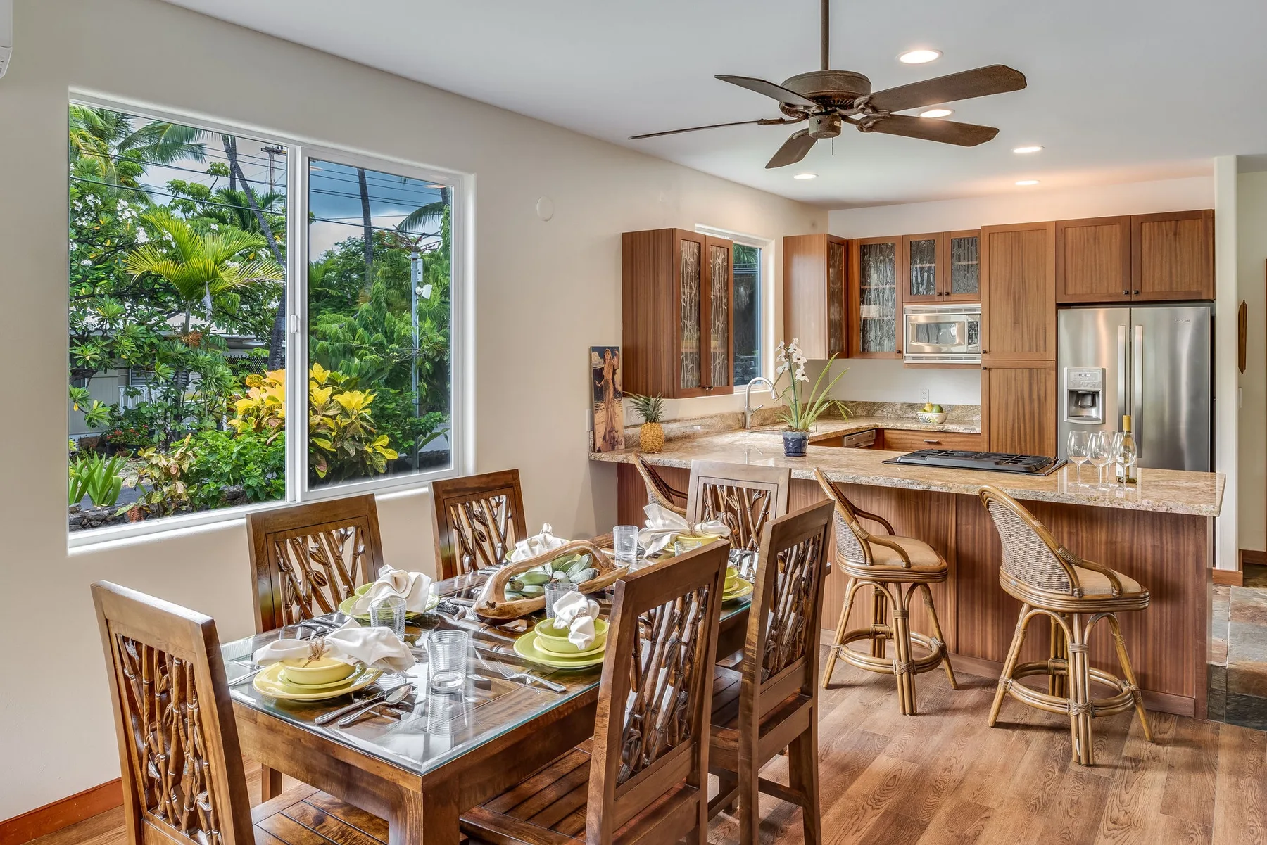 Un comedor con la mesa puesta junto a una cocina abierta.