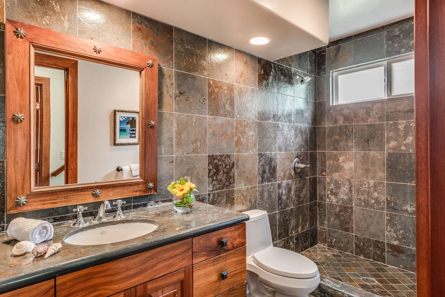Un baño con paredes de azulejos, lavabo, inodoro y zona de ducha.