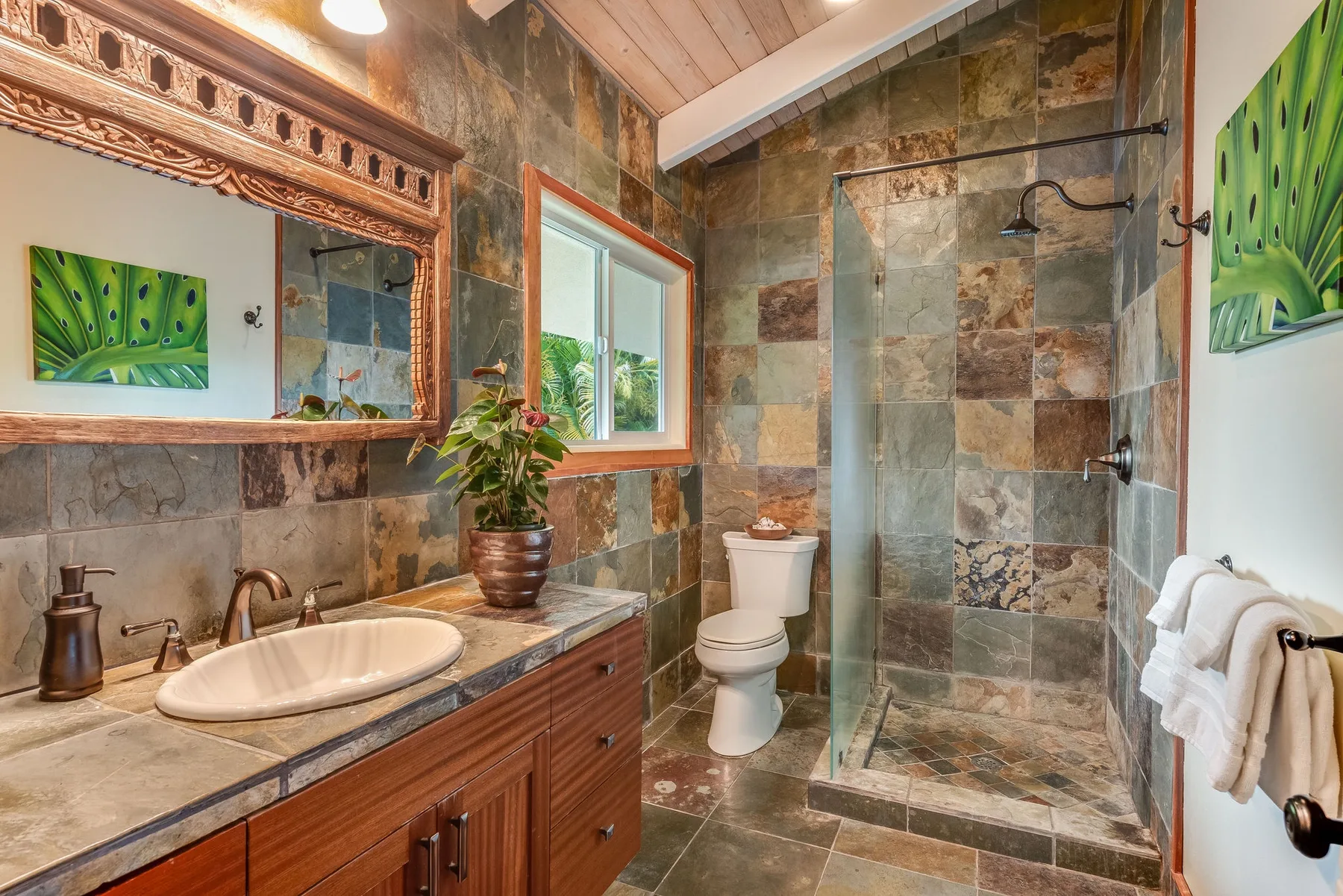Un baño con azulejos, tocador, inodoro y ducha de vidrio.