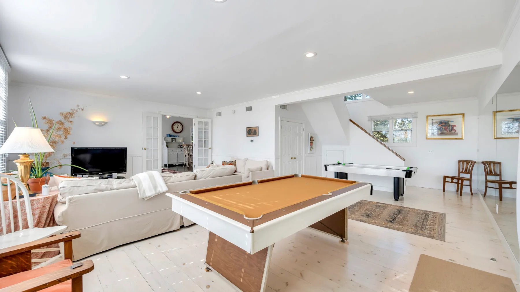 A bright living room with a large game table and seating.