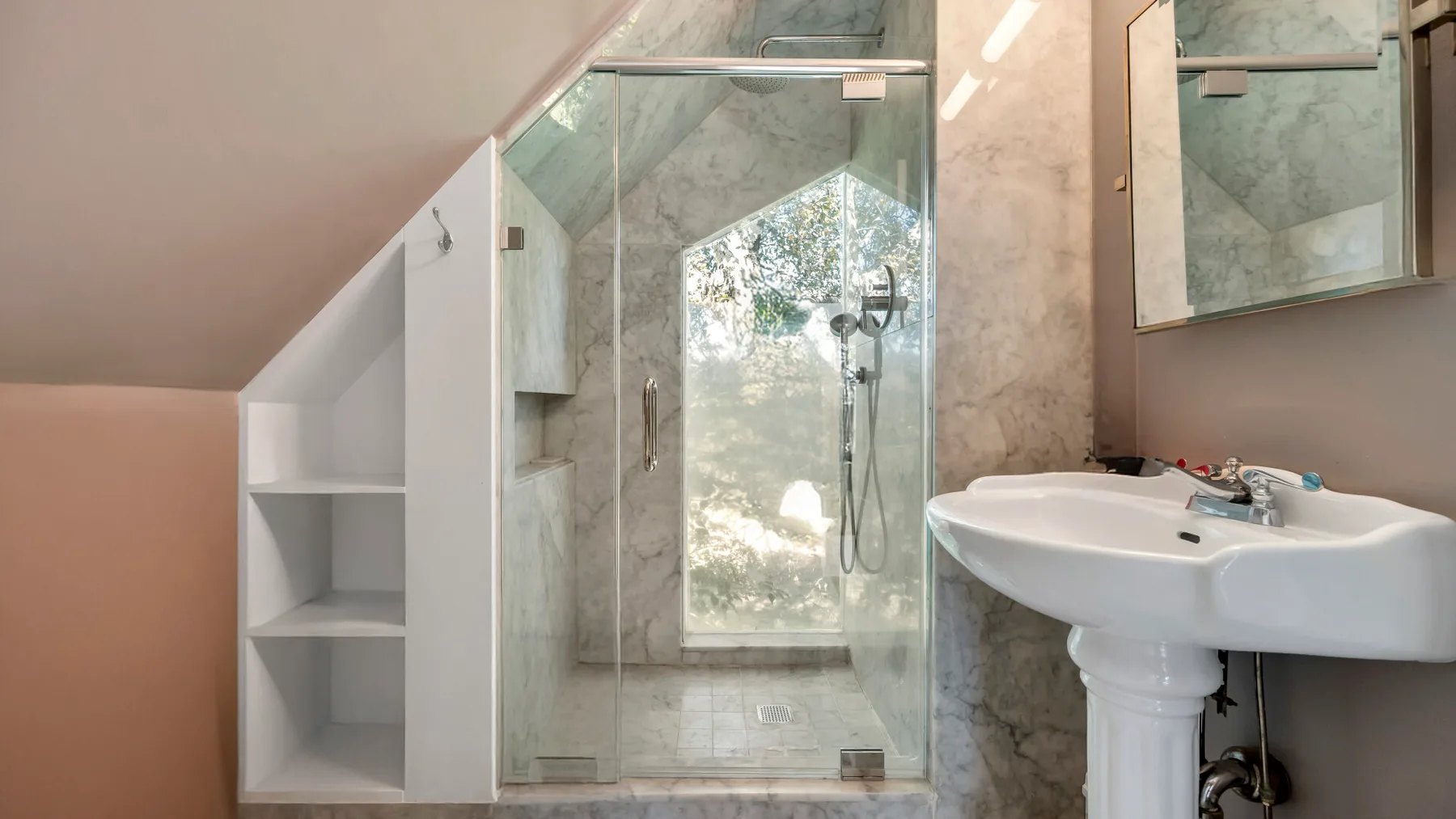 A bright bathroom with a glass shower and a white sink.