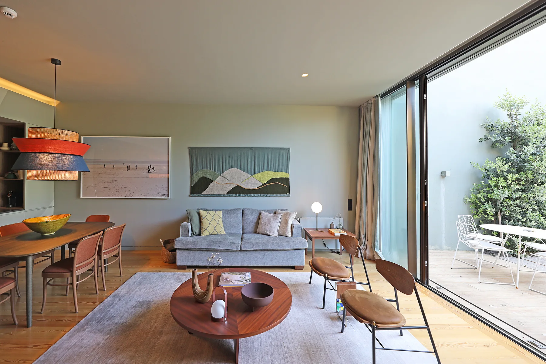 A bright living and dining area opens onto a patio through large glass doors.