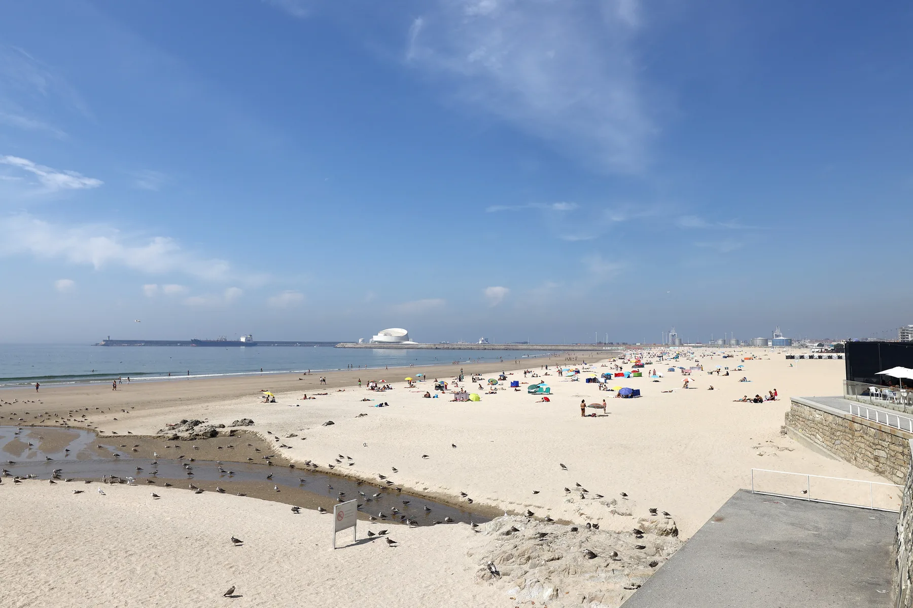 A sandy beach stretches along the shoreline beneath a clear blue sky.