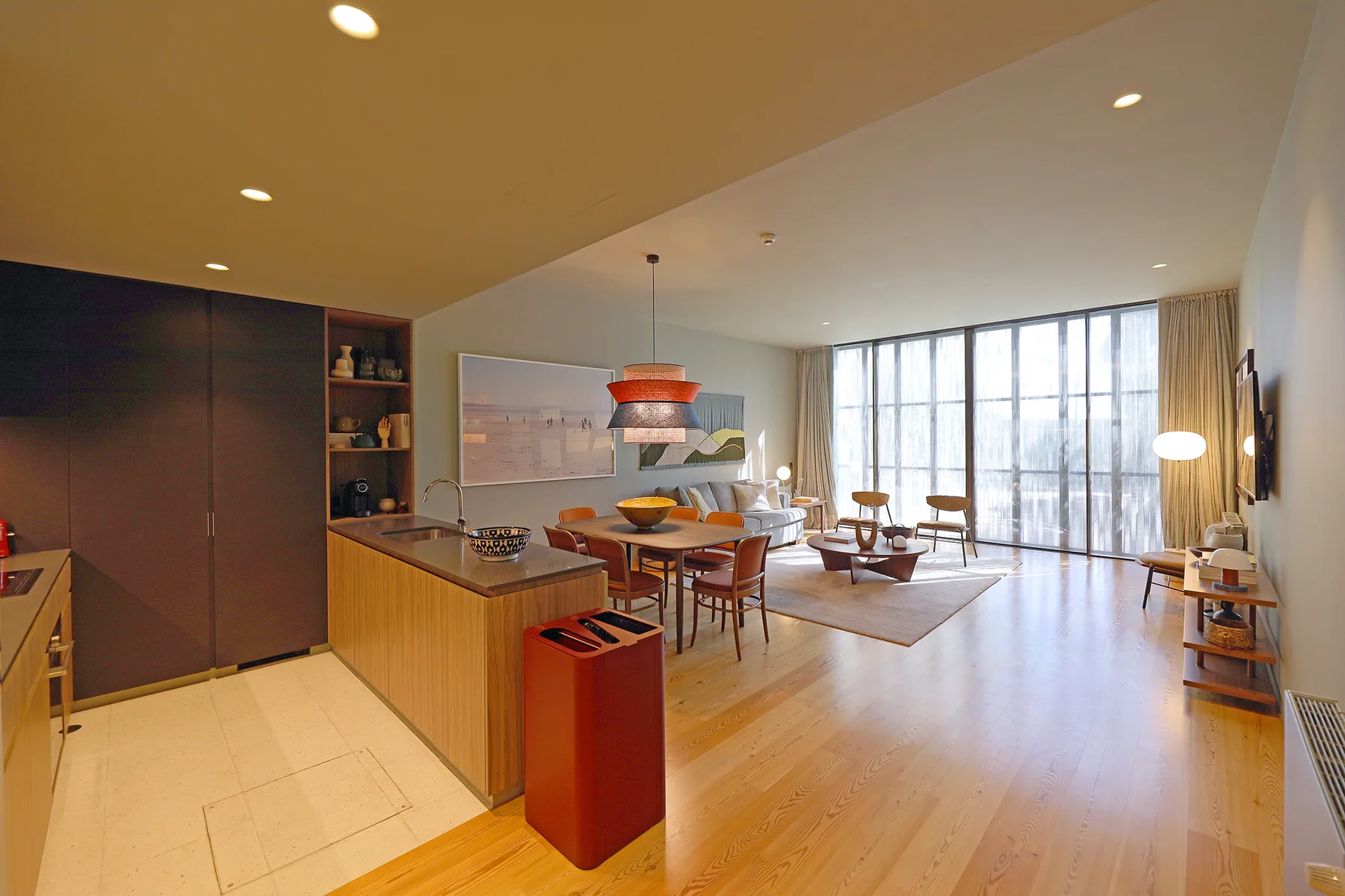 An open-plan living and dining area with a kitchen island and large windows.