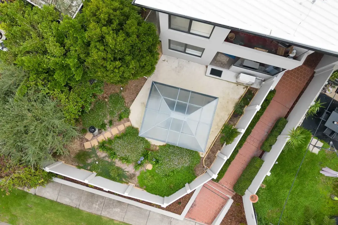 Aerial view of a modern house and landscaped garden.