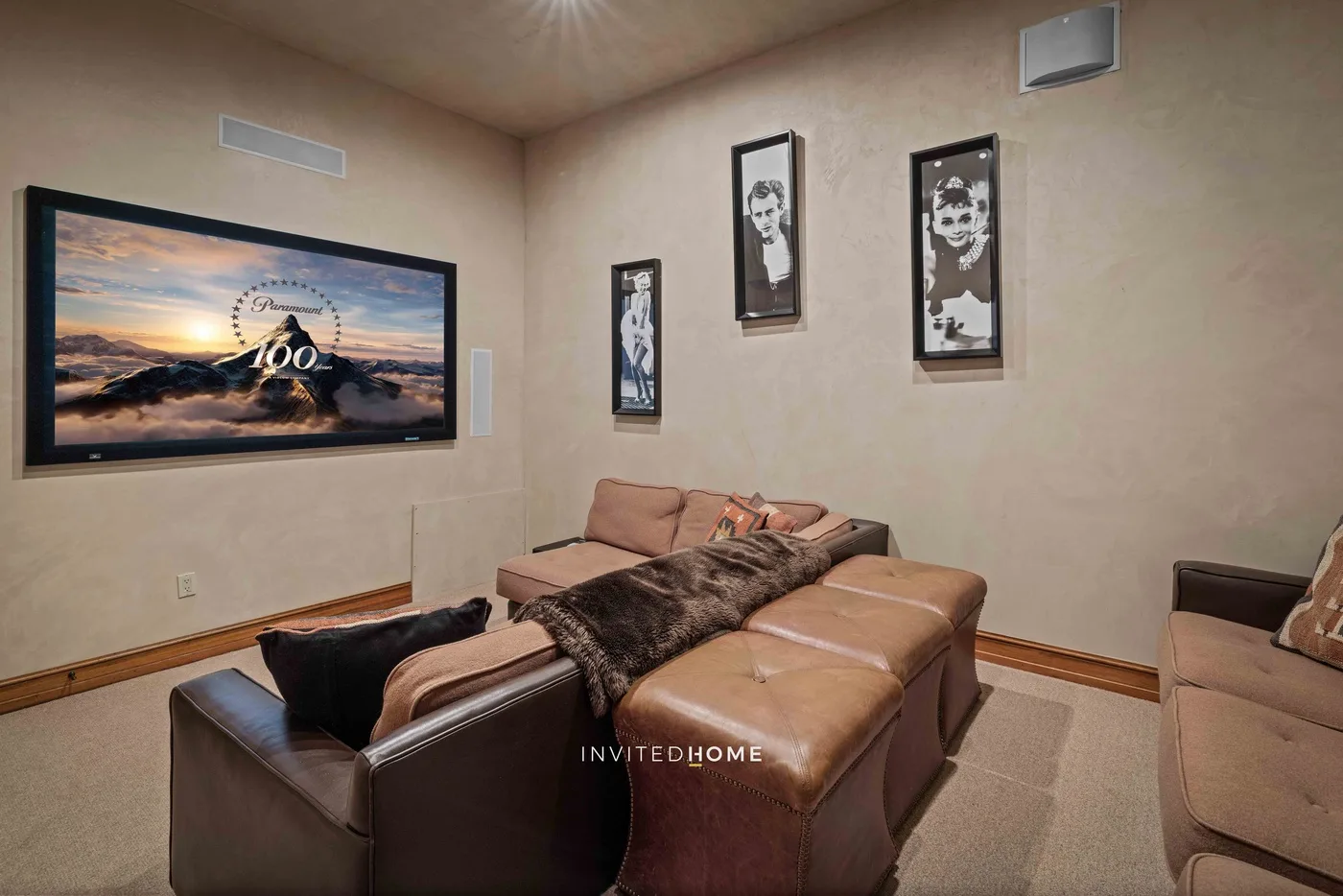A living room with leather seating and framed pictures on the walls.