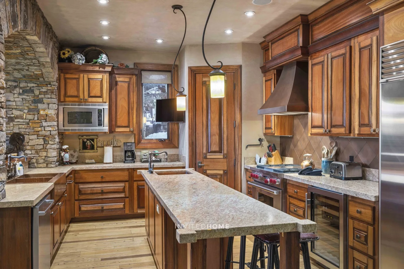 A spacious kitchen with wooden cabinetry and a long central island.