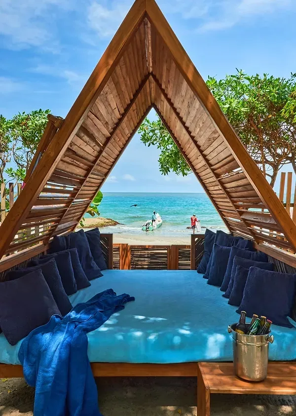 Cama bajo un dosel de madera en la playa
