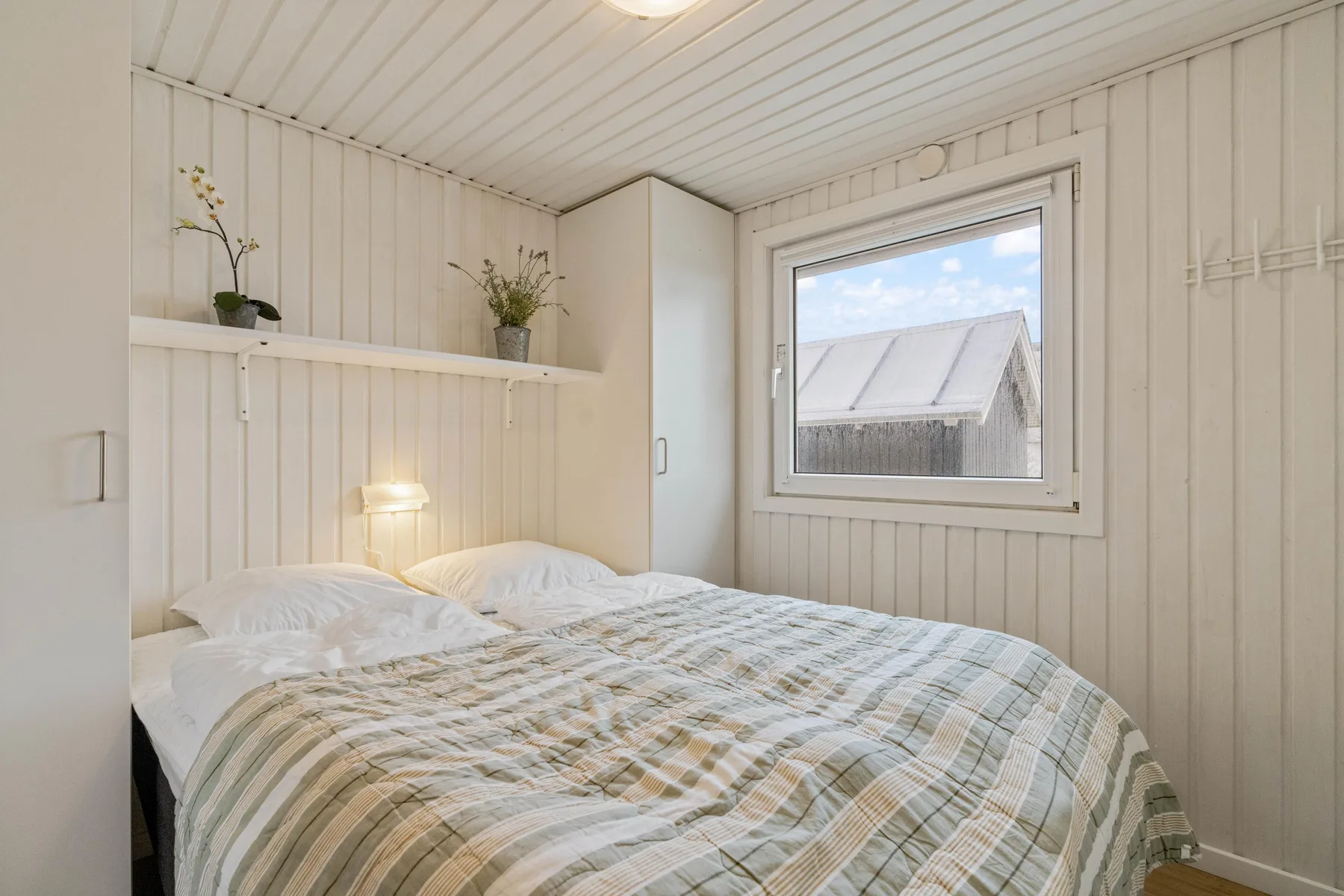 Un dormitorio con una cama doble junto a una ventana.