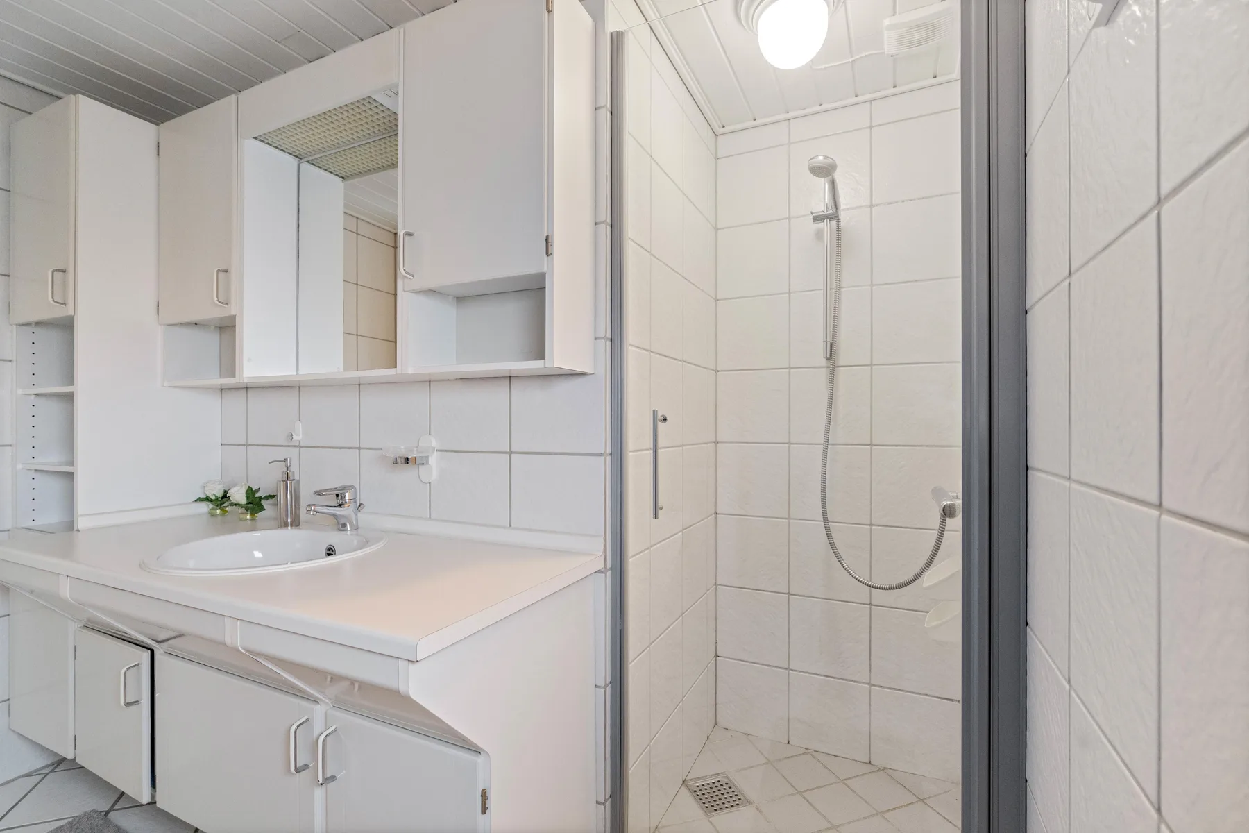 Un baño alicatado con lavabo y ducha.