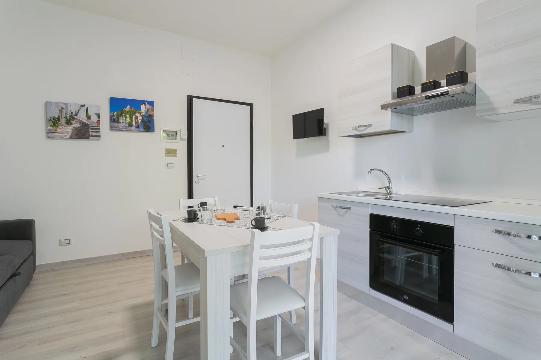 A bright kitchen and dining area with a white table and built-in oven.