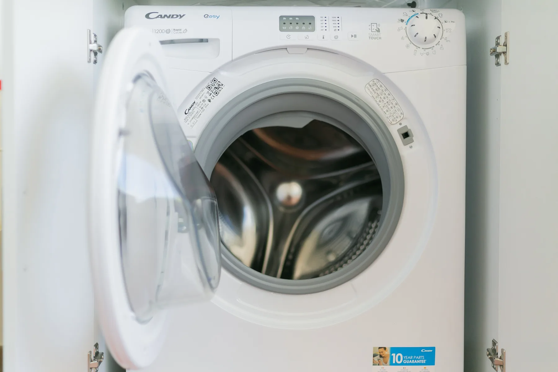 A front-loading washing machine with its circular door open.