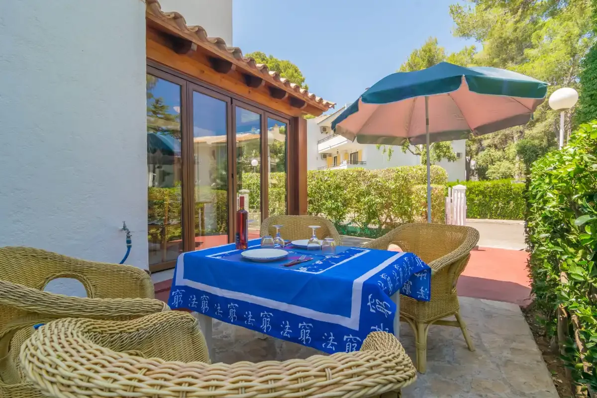 A patio dining area with a table beneath a large umbrella.