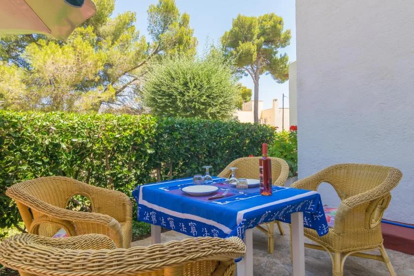 An outdoor patio dining area with a blue tablecloth and wicker seating.