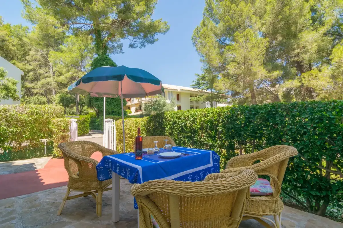 An outdoor dining area with wicker seating and a blue-covered table.