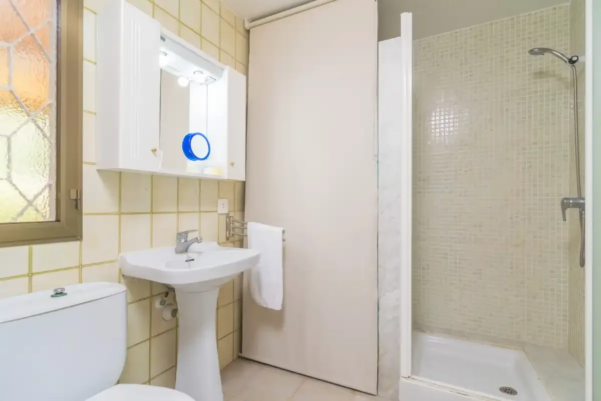A tiled bathroom with a sink, toilet, and shower.