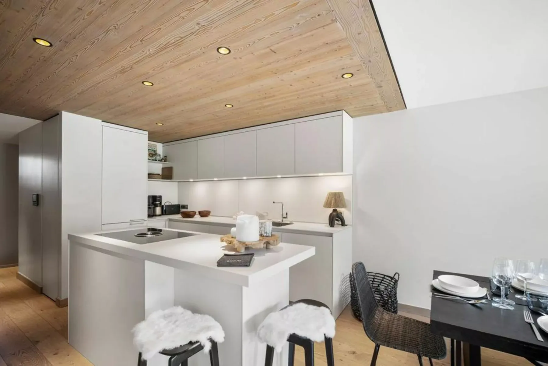 A modern kitchen with a white island and a dining table.