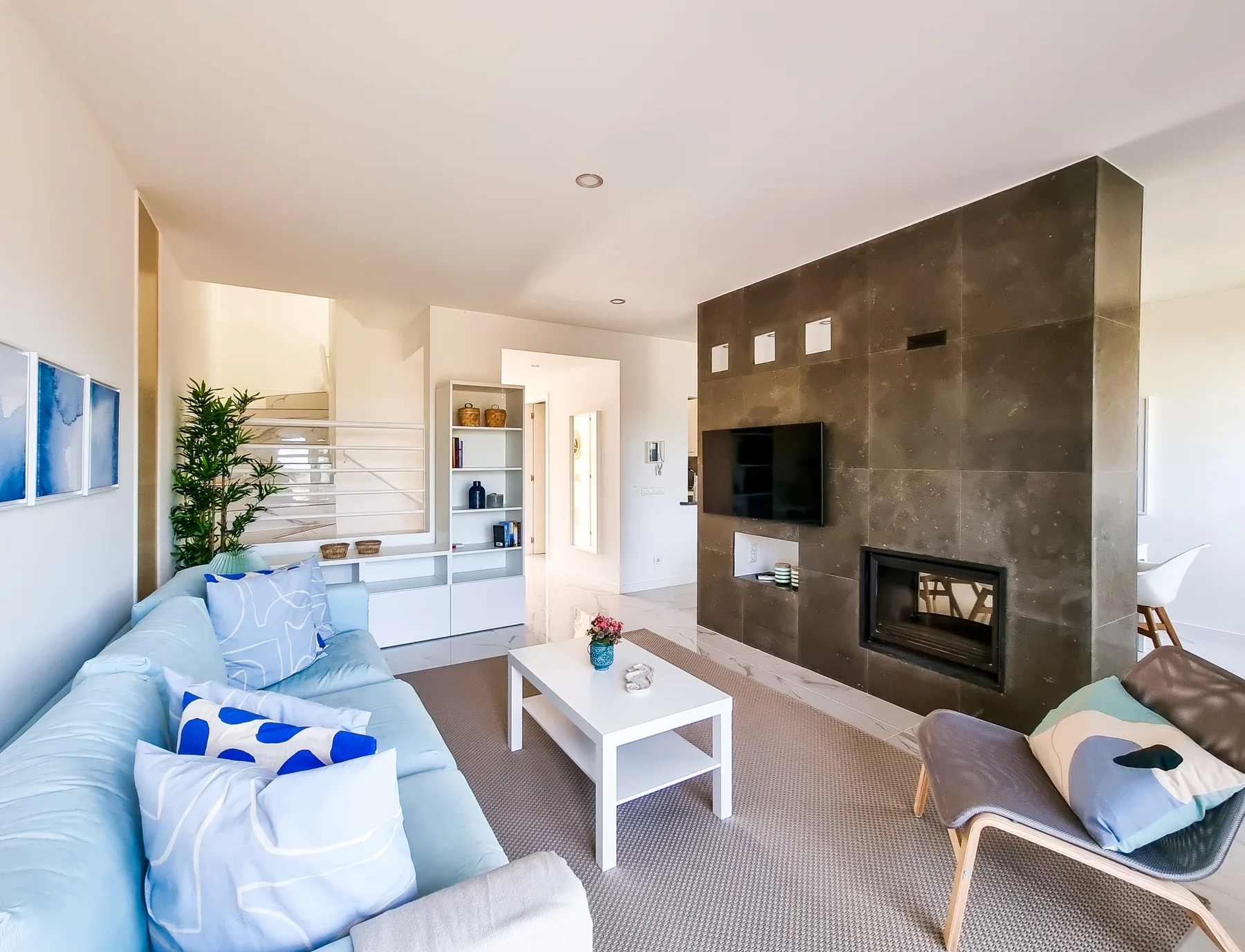 Living room with seating, a coffee table, and a wall-mounted television.